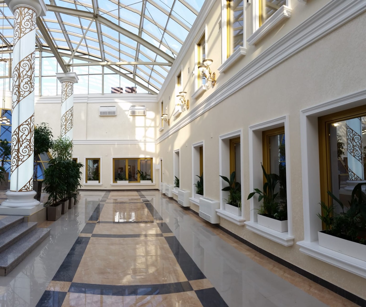 Bright interior atrium with glazed roof and decorative columns