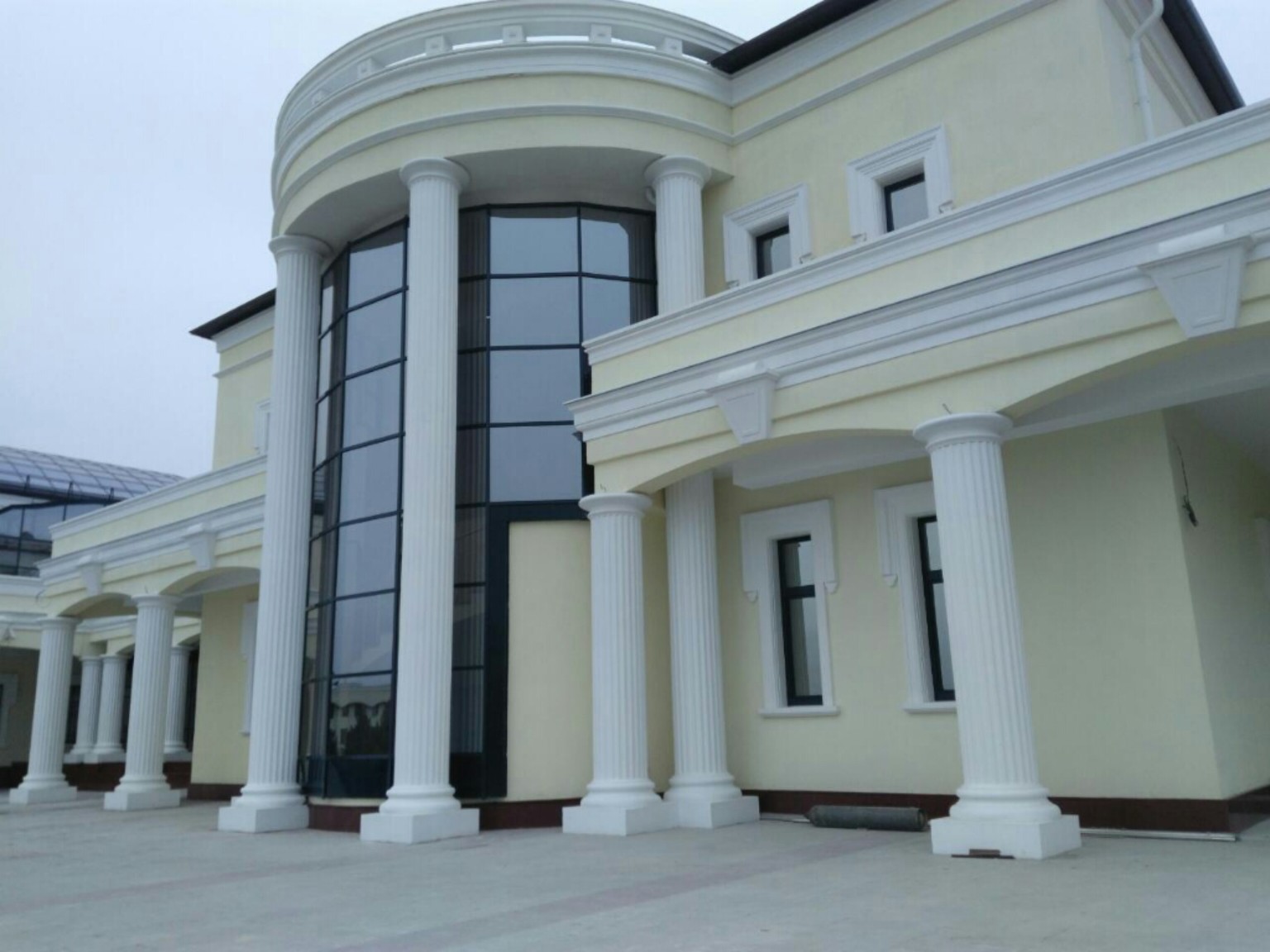 Classical building exterior with columns and curved glazed entrance